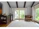 Sitting room with built-in bar, dark wood floors, beamed ceiling, a leather armchair, and large windows with natural light at 965 Tiverton Ln, Alpharetta, GA 30022