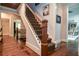Elegant staircase with dark wood railings, patterned carpet, and trim detail in bright, naturally lit foyer at 965 Tiverton Ln, Alpharetta, GA 30022