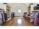 Open walk-in closet with hardwood floors, center window, and plenty of storage at 965 Tiverton Ln, Alpharetta, GA 30022