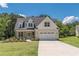 Charming two-story home with a brick and siding facade, well-manicured lawn, and a two-car garage at 4075 O Henry Ct, Mcdonough, GA 30252