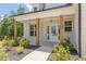 Inviting front porch with brick columns, a white front door, and manicured landscaping at 4075 O Henry Ct, Mcdonough, GA 30252