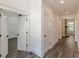 Bright hallway with wood-look floors, leading to bedroom and living area featuring a fireplace at 4075 O Henry Ct, Mcdonough, GA 30252