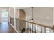 Hallway with hardwood flooring and a stone accent wall looking down to the fireplace below at 4075 O Henry Ct, Mcdonough, GA 30252