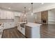 Kitchen with island, stainless steel appliances, white cabinets, and stone fireplace in the background at 4075 O Henry Ct, Mcdonough, GA 30252