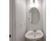 Simple powder room with a pedestal sink, oval mirror, and neutral colored walls at 436 Crestmont Ln, Canton, GA 30114