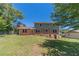 Lush backyard featuring a brick home, mature trees, and a well-maintained lawn at 5166 Vivid Dr, Stone Mountain, GA 30087
