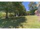 Expansive backyard featuring mature trees, storage shed, and lush green lawn providing a serene outdoor space at 5166 Vivid Dr, Stone Mountain, GA 30087