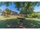 Expansive backyard with mature trees, a garden bed, and a partial view of the charming two-story home at 5166 Vivid Dr, Stone Mountain, GA 30087