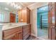 Bathroom features a wood vanity with sink, a framed mirror, and an open doorway leading to the walk-in closet at 5166 Vivid Dr, Stone Mountain, GA 30087