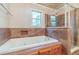 Inviting bathroom featuring a large soaking tub, adjacent shower, and tiled surround with a window view at 5166 Vivid Dr, Stone Mountain, GA 30087