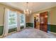 Elegant dining room featuring chandelier, large windows with backyard view, and doorway to kitchen at 5166 Vivid Dr, Stone Mountain, GA 30087