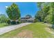 Traditional two-story home with a well-manicured lawn, mature trees, and a long driveway, perfect for suburban living at 5166 Vivid Dr, Stone Mountain, GA 30087