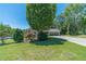 Well-manicured front yard featuring mature trees, lush greenery, and a charming home in the background at 5166 Vivid Dr, Stone Mountain, GA 30087