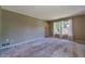 Cozy living room featuring plush carpeting, natural light from the windows, and soft, neutral paint at 5166 Vivid Dr, Stone Mountain, GA 30087