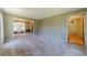 Open-concept living room with neutral carpet, seamlessly connecting to the dining area at 5166 Vivid Dr, Stone Mountain, GA 30087