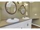 Bathroom featuring double vanity, oval mirrors, stylish fixtures, and a neutral paint palette at 940 Planters Pl, Loganville, GA 30052