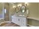 Well-lit bathroom with double vanity, oval mirrors, stylish fixtures, and a glass enclosed shower at 940 Planters Pl, Loganville, GA 30052