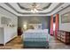 This well lit bedroom features a tray ceiling with a ceiling fan and neutral paint at 940 Planters Pl, Loganville, GA 30052