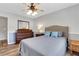 This well-lit bedroom features wood floors, neutral paint, a ceiling fan, and lots of natural light at 940 Planters Pl, Loganville, GA 30052