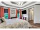 Bright bedroom featuring wood floors, tray ceiling, and modern furnishings at 940 Planters Pl, Loganville, GA 30052