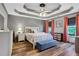 Beautiful bedroom with a decorative tray ceiling, hardwood floors, and elegant furnishings at 940 Planters Pl, Loganville, GA 30052
