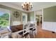 Bright dining room with hardwood floors, decorative chandelier, and sun-lit windows makes for a comfortable dining space at 940 Planters Pl, Loganville, GA 30052