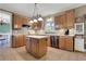 Traditional kitchen featuring wooden cabinets, tile backsplash, stainless steel appliances, and a central island at 940 Planters Pl, Loganville, GA 30052