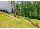 An expansive backyard showcases wooden steps leading to a deck surrounded by trees, offering a private outdoor retreat at 1013 Liberty Springs Dr, Woodstock, GA 30188
