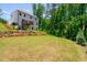 A spacious backyard with a deck is complemented by landscaping and wooden steps down a gentle slope at 1013 Liberty Springs Dr, Woodstock, GA 30188