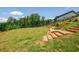 An expansive backyard featuring well-maintained landscaping with rock features and wooden steps on a gently sloping lawn at 1013 Liberty Springs Dr, Woodstock, GA 30188