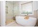 Modern bathroom with a standalone tub, glass shower, and stylish tile work, all naturally lit at 1013 Liberty Springs Dr, Woodstock, GA 30188
