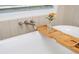 Bright bathroom featuring a soaking tub with elegant fixtures and a convenient wooden tray at 1013 Liberty Springs Dr, Woodstock, GA 30188