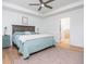 Bright bedroom featuring tray ceilings, natural light, light hardwood floors, stylish teal dresser and a rug at 1013 Liberty Springs Dr, Woodstock, GA 30188