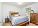 Bedroom featuring a comfortable bed, wooden furniture, and natural light from the window at 1013 Liberty Springs Dr, Woodstock, GA 30188