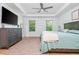 Spacious bedroom with tray ceilings, natural light, light hardwood floors, stylish gray dresser and a rug at 1013 Liberty Springs Dr, Woodstock, GA 30188