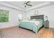 Spacious bedroom with tray ceilings, natural light, light hardwood floors, and a stylish rug at 1013 Liberty Springs Dr, Woodstock, GA 30188