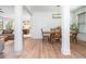 Open-concept dining area with a view of the kitchen and living room featuring an eye-catching modern chandelier and hardwood floors at 1013 Liberty Springs Dr, Woodstock, GA 30188