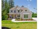 Charming two-story home with a manicured lawn, beautiful landscaping, and a welcoming front porch at 1013 Liberty Springs Dr, Woodstock, GA 30188