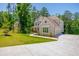 Beautiful two-story home with a two-car garage and a well-manicured lawn nestled in a wooded community on a sunny day at 1013 Liberty Springs Dr, Woodstock, GA 30188