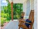 Cozy front porch featuring rocking chairs with plush cushions and a view of a beautifully landscaped yard at 1013 Liberty Springs Dr, Woodstock, GA 30188