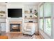 Stylish living room featuring a fireplace with built-ins and sun-drenched windows offering picturesque views at 1013 Liberty Springs Dr, Woodstock, GA 30188