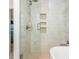 Elegant bathroom with a glass-enclosed shower featuring tiled walls and recessed shelving at 1013 Liberty Springs Dr, Woodstock, GA 30188