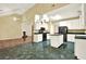 Open kitchen area with white cabinets, an island, black appliances, and a view into the living room fireplace at 2949 Spotted Pony Nw Ct, Acworth, GA 30101