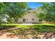 Exterior view of home with a grassy backyard, patio, mature trees and lawn at 5125 Winding Glen Dr, Lithonia, GA 30038