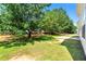 Large, green backyard featuring healthy green grass, a patio, and mature trees at 5125 Winding Glen Dr, Lithonia, GA 30038