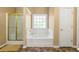 Bright bathroom featuring a tiled jacuzzi tub, glass shower, and tiled floors at 5125 Winding Glen Dr, Lithonia, GA 30038