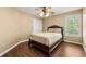 Cozy bedroom with hardwood floors, a comfortable bed, and a view of the outdoors at 5125 Winding Glen Dr, Lithonia, GA 30038