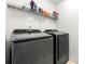 Clean and modern laundry room with brand new Samsung front-loading washer and dryer and wire shelving at 5125 Winding Glen Dr, Lithonia, GA 30038