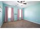 Inviting bedroom with soft blue walls, neutral carpet, and large windows at 1015 Carriage Way, Loganville, GA 30052