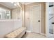 Bright bathroom features a white vanity, white wall paneling, and large mirror above the bench at 2796 County Line Rd, Acworth, GA 30101